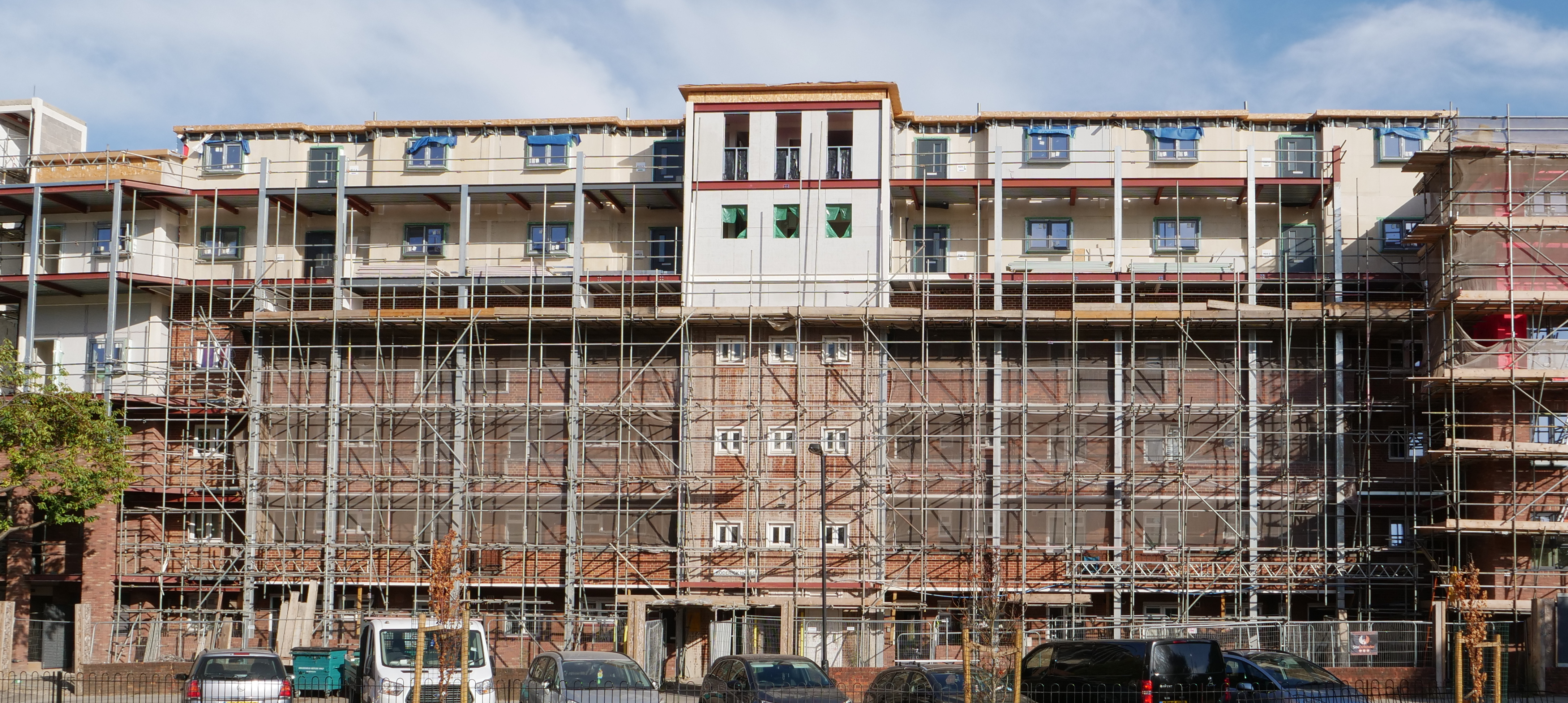 Roderick House in profile showing the building covered in scaffolding, with the new prefabricated modules placed on top.